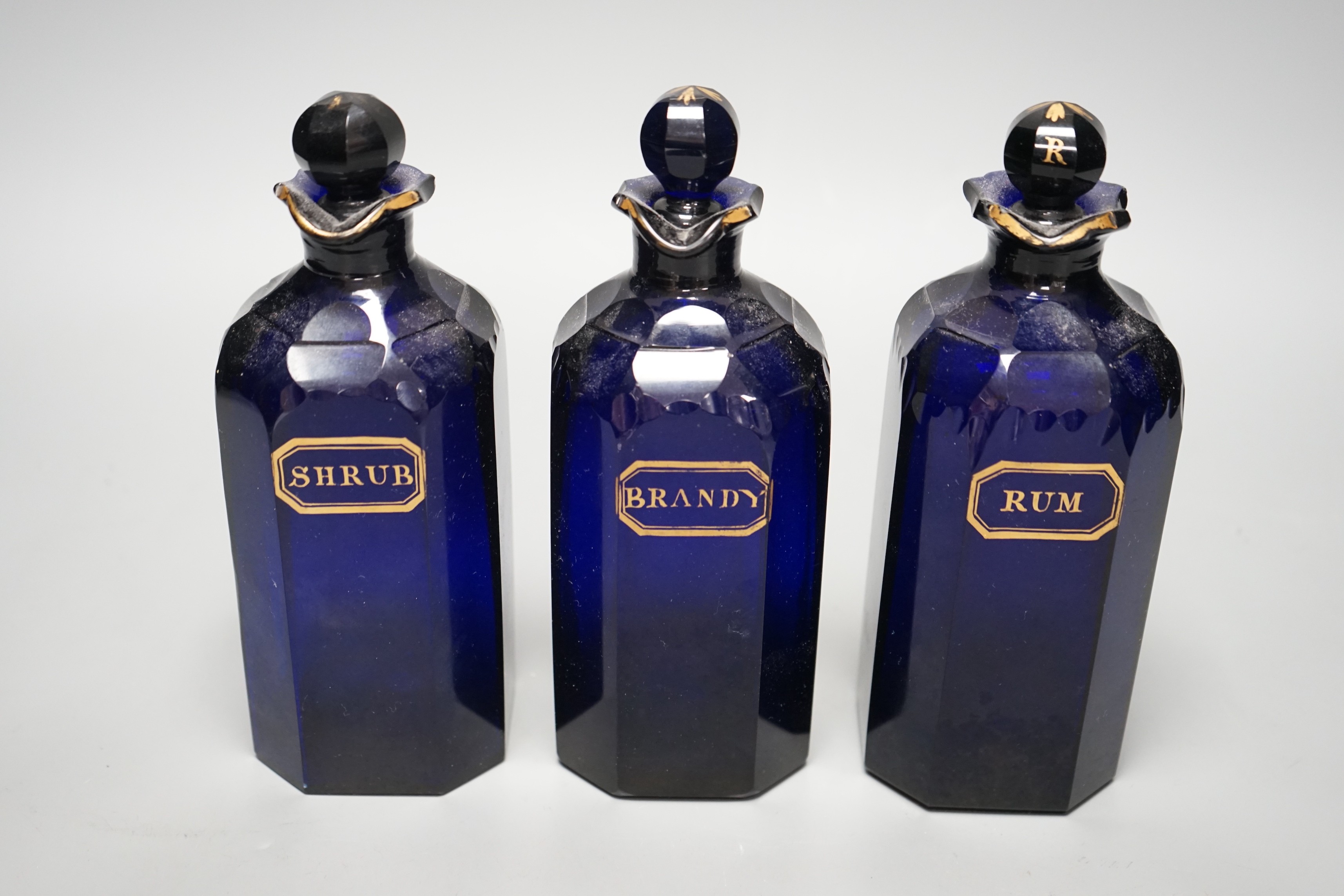 Three Georgian Bristol Blue gilt labelled decanters, ‘rum’, ‘brandy’ and ‘shrub’ 20cm